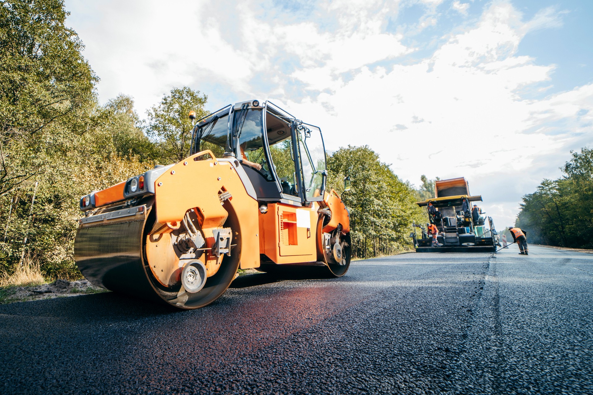 Vibratory asphalt rollers compactor compacting new asphalt pavement. Road service repairs the highway